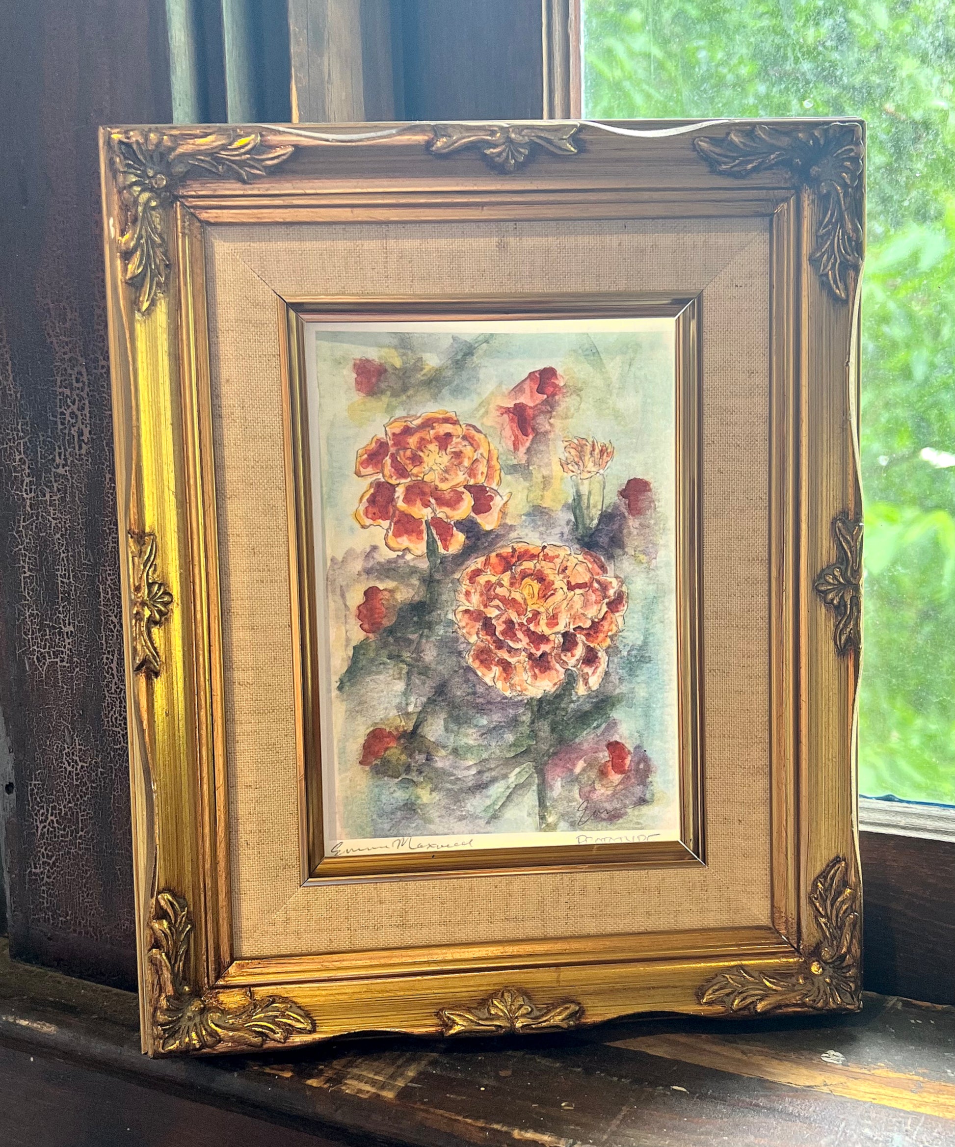 Framed marigold painting on a vintage window sill 